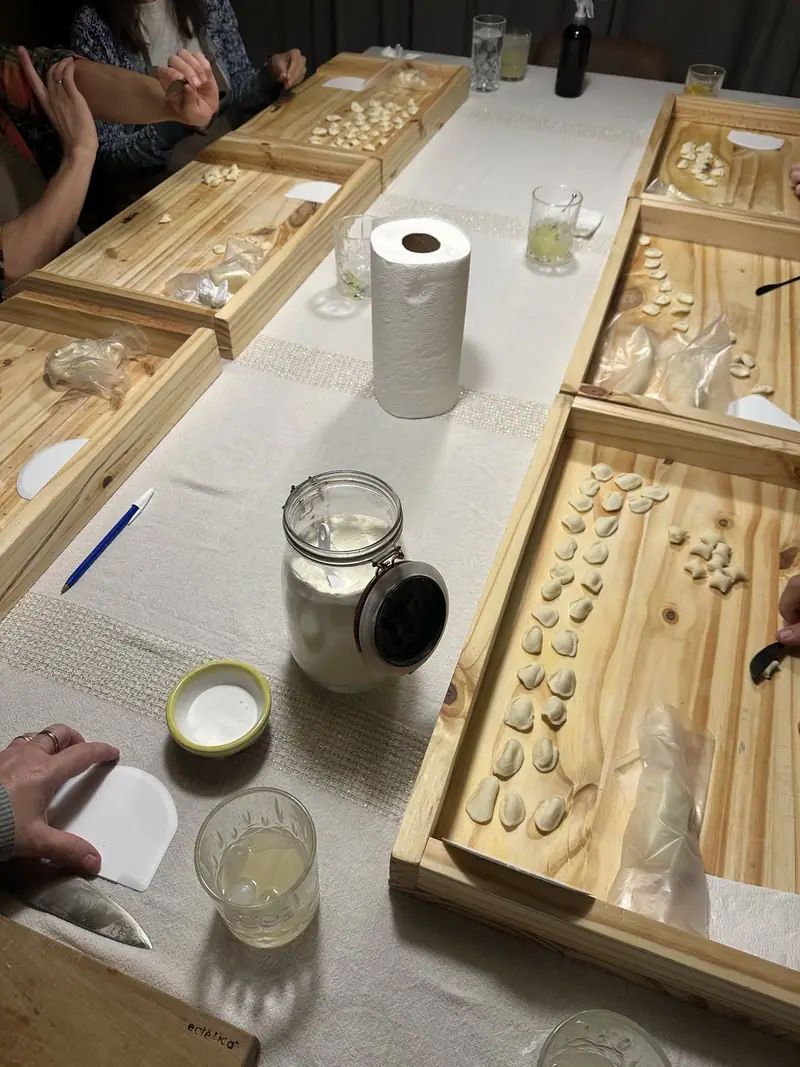 Mesa del workshop con orecchiette recién formadas sobre tablas de madera